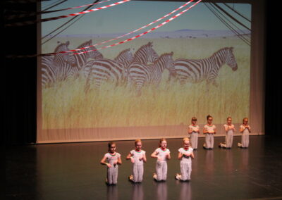 Kinder auf Bühne mit Zebra im Hintergrund